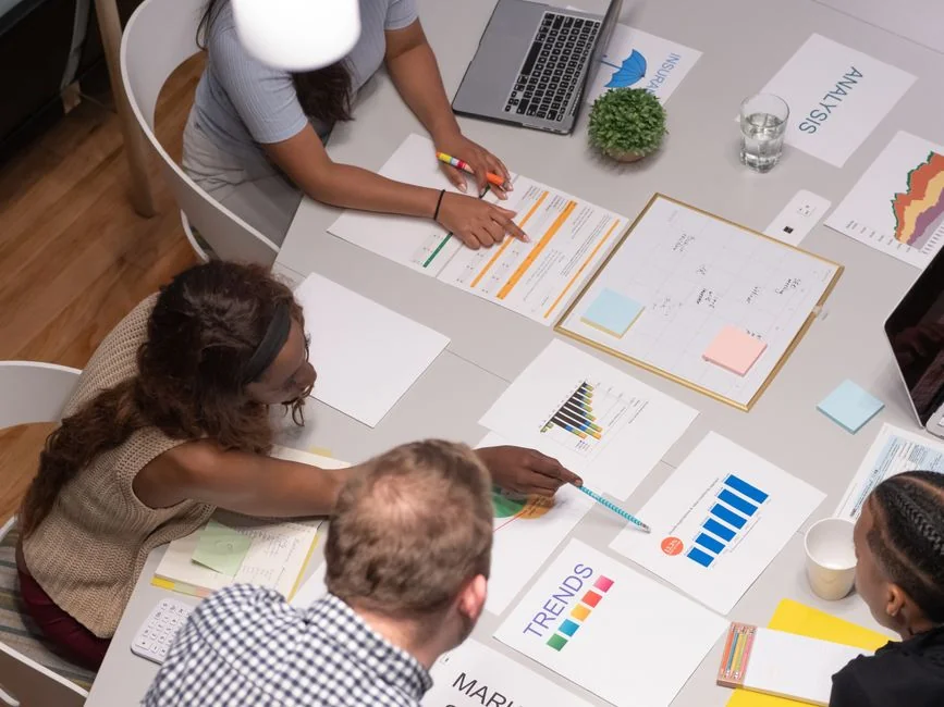 Two colleagues brainstorm ideas on a whiteboard during a creative strategy session.